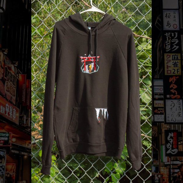 Steinblokk - Hoodie hanging on chain link fence with foliage behind it