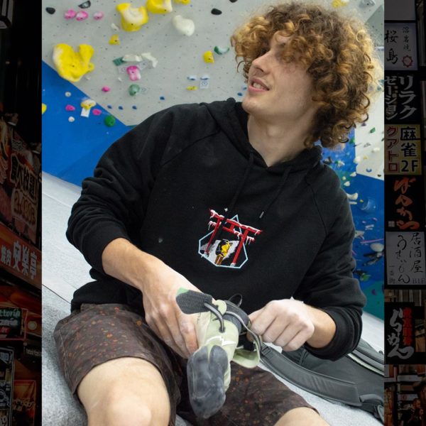 Steinblokk - male rock climber wearing hoodie while putting on climbing shoe