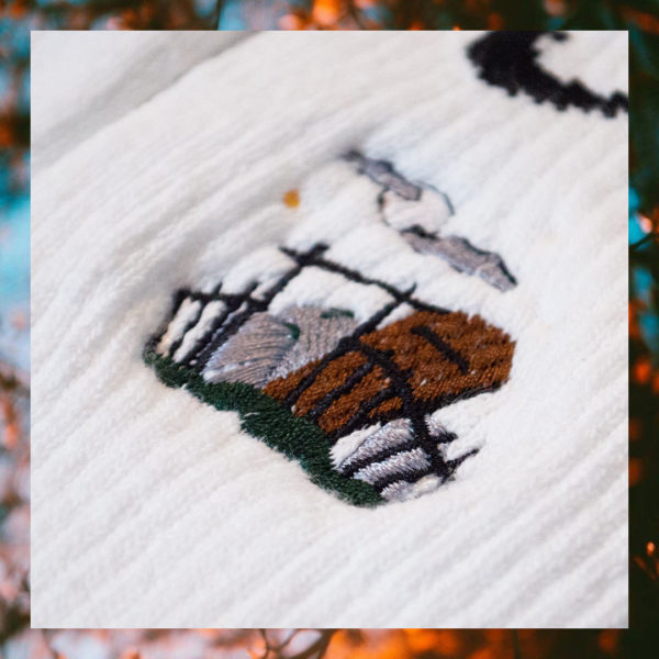 White crew sock featuring an embroidered cemetery scene