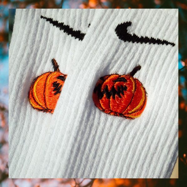 pair of embroidered crew socks featuring a jack-o-lantern design